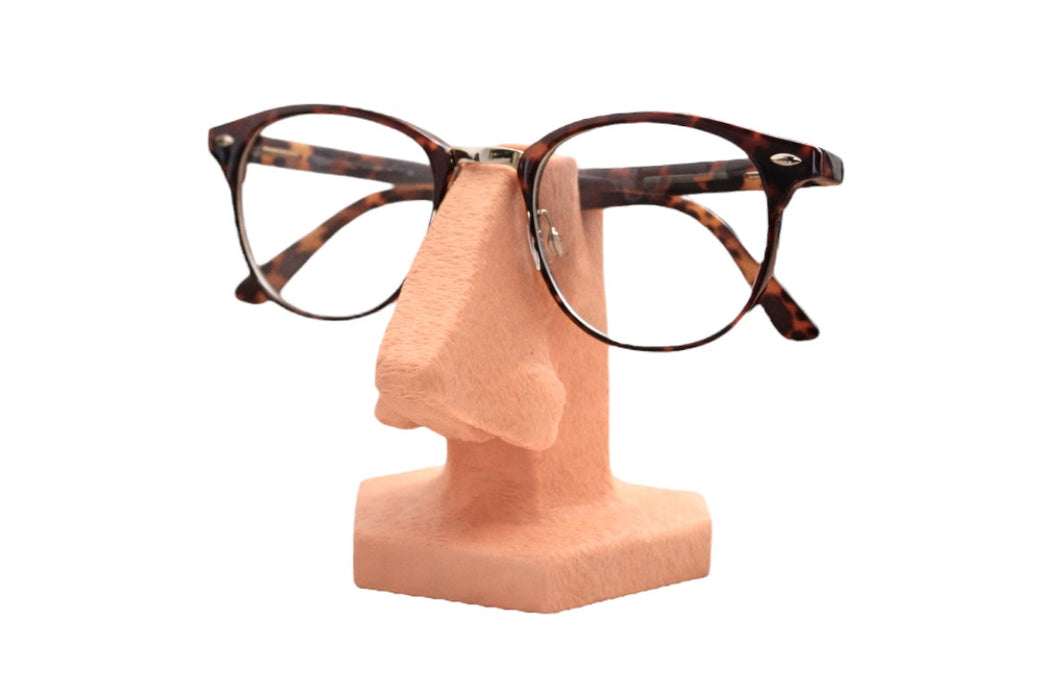 Soporte para gafas con forma de nariz visto en angulo sosteniendo unas gafas