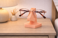 Soporte para gafas con forma de nariz sobre una mesa en un entorno decorativo